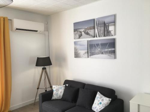 a living room with a couch and two pictures on the wall at Gîte du Petit Poucet in Saint-Hilaire-de-Riez