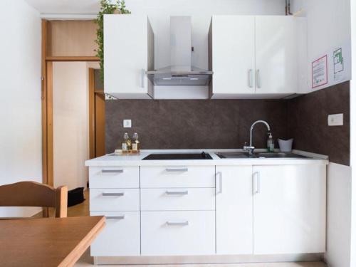 a kitchen with white cabinets and a sink at Apartma Matajurc in Trnovo ob Soči