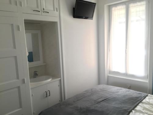 a white bedroom with a bed and a sink at Gîte du Petit Poucet in Saint-Hilaire-de-Riez