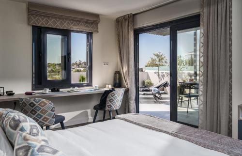 una camera con letto, scrivania e balcone di Urban Nest - Suites & Apartments ad Atene