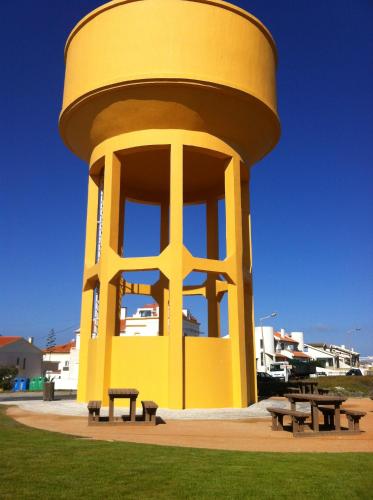 a yellow tower with benches in a park at Peniche Surf Lodge 2 in Peniche