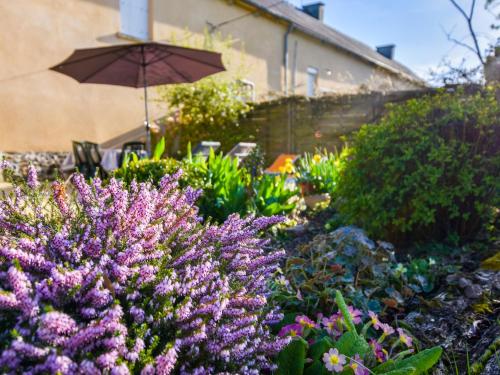 a garden with purple flowers and an umbrella at Elegant Escape in Lanrelas in Lanrelas