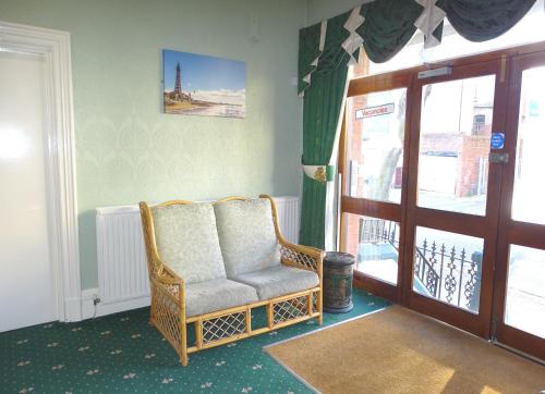 a wicker chair sitting in a room next to a door at Beeton Villas Holiday Apartments in Blackpool