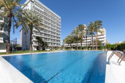 a large swimming pool with palm trees and buildings at AG FLORIDA in Playa de Gandia
