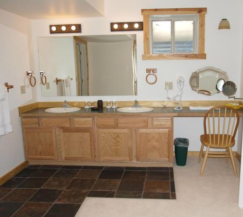 a bathroom with two sinks and a large mirror at Yellowstone Basin Inn in Gardiner