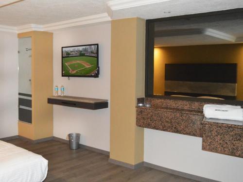 Habitación de hotel con TV de pantalla plana en la pared en Hotel Seoul, en Ciudad de México