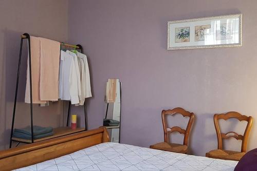 a bedroom with a bed and two chairs and a mirror at Gîte Ker André à 15 minutes du Puy du Fou in Pouzauges