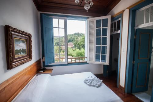 a bedroom with a large bed and a window at Hotel Solar de Maria in Ouro Preto
