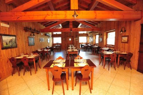 jadalnia z drewnianymi stołami i krzesłami w obiekcie Locanda Lac Place Moulin w mieście Bionaz