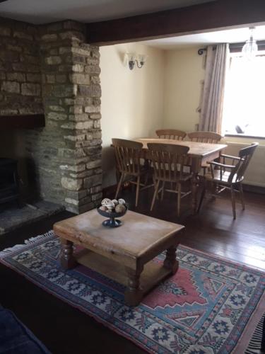 a living room with a table and a fireplace at The Forge in Corsham