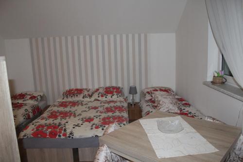 a small room with two beds and a table at Domek "Madzia" in Brenna