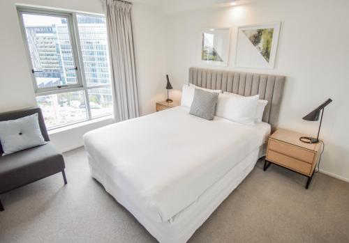 a bedroom with a large white bed and a window at Belise Apartments in Brisbane