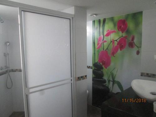 uma casa de banho com uma pintura de flores na parede em La Mansion del Rodadero em Santa Marta
