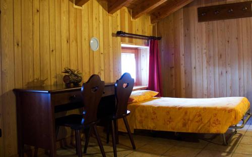 a bedroom with a bed and a desk and a bed and a table at Locanda Lac Place Moulin in Bionaz