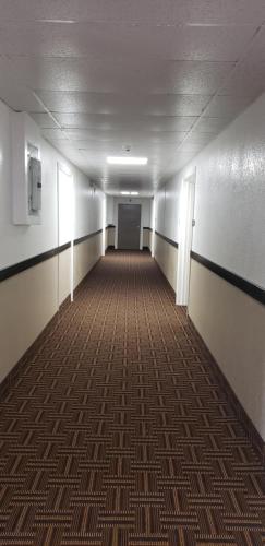 an empty hallway in an office building with a carpet at Travel Inn Of Sidney Ohio in Sidney