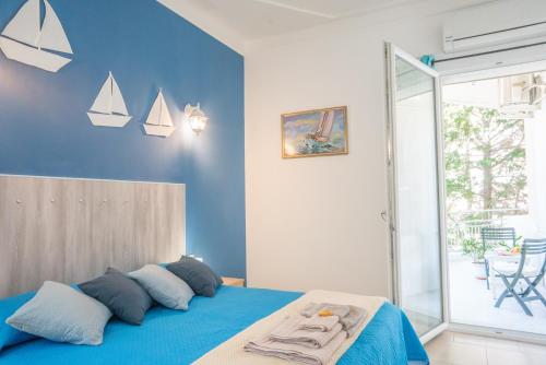 una camera da letto con pareti blu e un letto con cuscini di B&B Nell'Isola a Carloforte