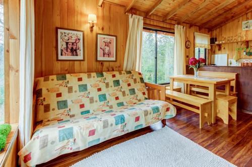 a bedroom with a bed and a desk in a room at Murmullo de Arroyos in Caburgua