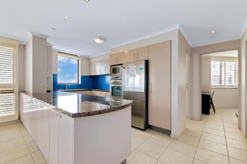 a kitchen with white cabinets and a counter top at Seaview Resort in Mooloolaba
