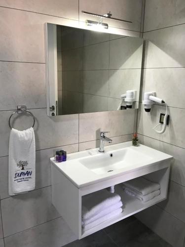 a bathroom with a sink and a mirror and towels at Duman Boutique Hotel Cesme in Çeşme