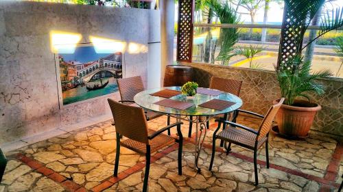 a dining room with a glass table and chairs at Residence Meridiana in Juan Dolio