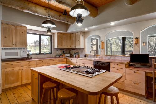 uma cozinha com armários de madeira e uma ilha com um fogão em Mariposa Lodge Bed and Breakfast em Steamboat Springs