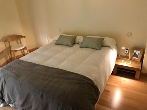 a bedroom with a large bed with two pillows at Atrio Zamora in Zamora