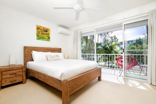 a bedroom with a bed and a large window at Moondarah Apartment 6, Noosa Heads in Noosa Heads