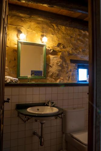 a bathroom with a sink and a mirror and a toilet at Masada Andabe in Las Cuevas de Cañart