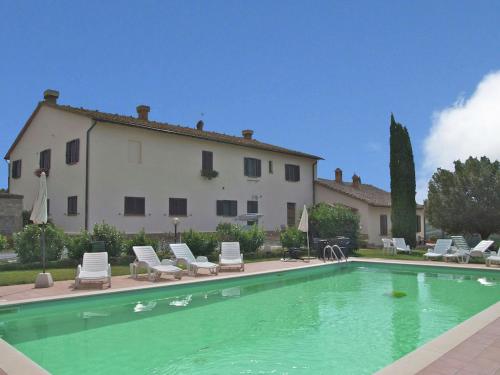 a swimming pool with chairs and a house at Authentic farmhouse in the Val D Orcia with pool and stunning views in Contignano