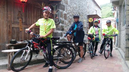 a group of men on bikes parked outside a building at Matsu 1st Hostel in Nangan