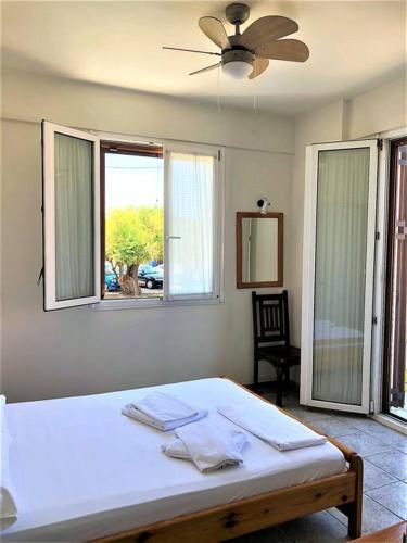 a bedroom with a bed and a large window at Mythos Suites-Apollo apartment in Methoni