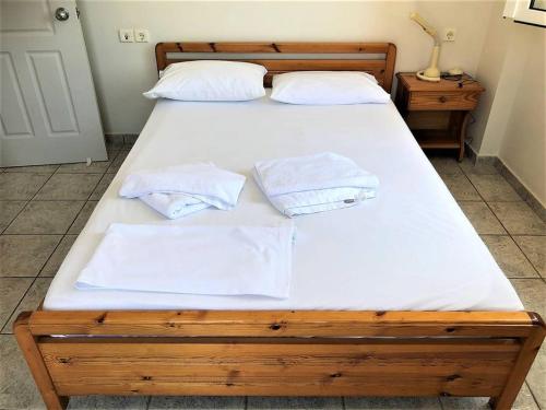 a bedroom with two beds with white sheets and towels at Mythos Suites-Apollo apartment in Methoni