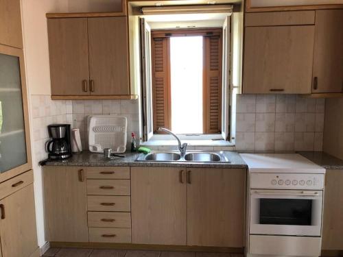 a kitchen with a sink and a window at Mythos Suites-Aphrodite apartment in Methoni
