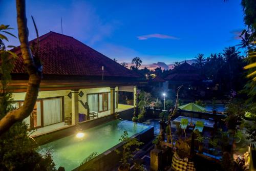 an image of a villa with a swimming pool at night at Ubud Wins Bungalow in Ubud