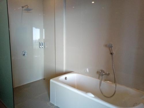 a bathroom with a bath tub and a shower at Atres Sari Resort in Munduk