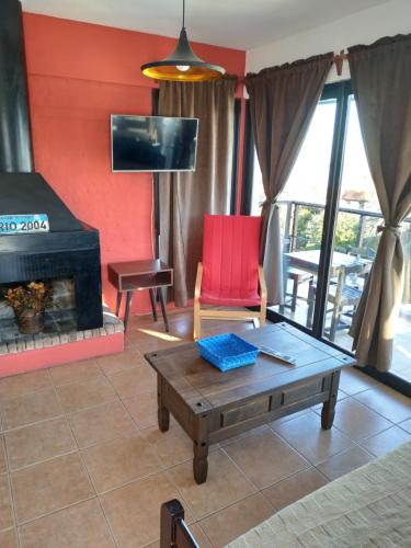 a living room with a red chair and a fireplace at Visión ESCAPE Piriápolis in Piriápolis