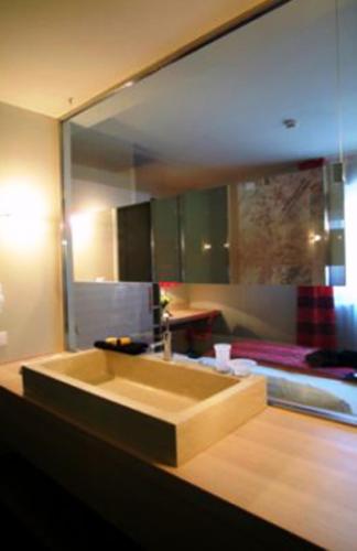 a bathroom mirror with a sink and a bed at El Homs Palace Hotel in Comiso