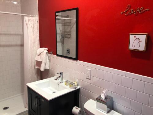 a bathroom with a sink and a red wall at The ART INN Seattle in Seattle