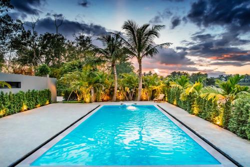 a swimming pool in the backyard of a house with palm trees at Natural Villas Chiang Mai Luxury Private Pool in Chiang Mai