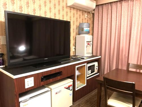 ein Wohnzimmer mit Fernseher und Tisch in der Unterkunft Pal Annex Nakatsu (Love Hotel) in Nakatsu