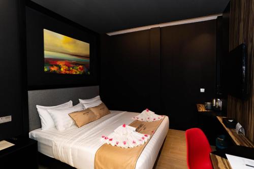 a bedroom with a bed with two cakes on it at Artworks Hotel Ipoh in Ipoh