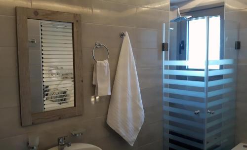 a bathroom with a sink and a mirror and a towel at Beach House in Plakias