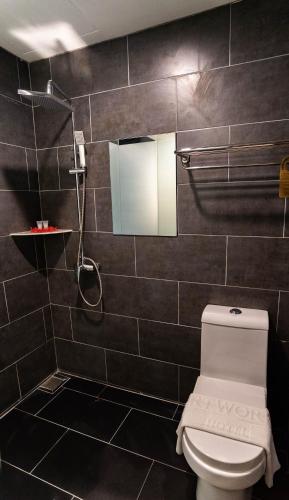 a bathroom with a toilet and a shower at Artworks Hotel Ipoh in Ipoh