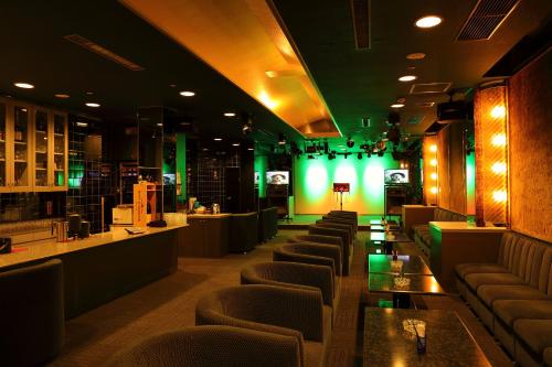 a restaurant with a bar with green lighting and couches at Arima Gyoen in Kobe