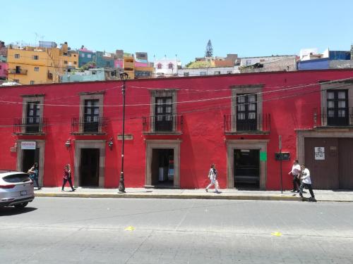 a red building with people walking in front of it at Hotel Dos Rios in Guanajuato