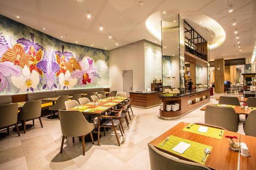 a restaurant with tables and chairs and a floral wall at Bigland Hotel & Convention Sentul in Bogor