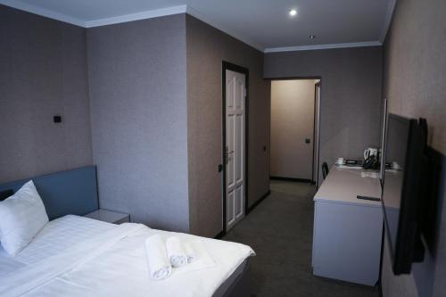 a hotel room with a bed and a sink at Olympica Hotel in Almaty