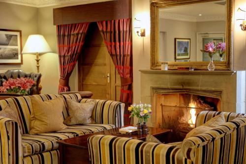 a living room with two couches and a fireplace at Three Ways House Hotel in Chipping Campden