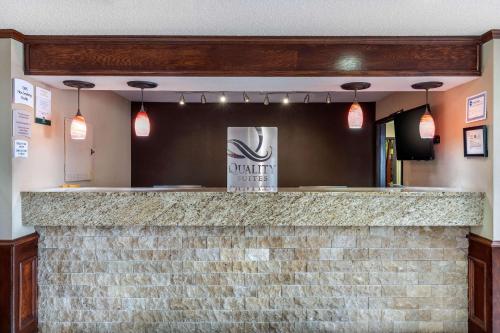 a bar in a restaurant with a brick wall at Quality Suites Addison-Dallas in Addison
