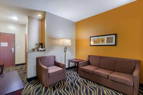 a hotel room with a couch and a chair at Quality Suites Addison-Dallas in Addison
